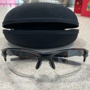 Oakley Flak 2.0 Sunglasses. Black matte frame, silver Oakley logo, clear lens.